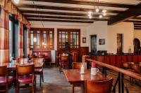 um restaurante com mesas e cadeiras de madeira e um bar em Das Ebertor - Hotel & Hostel em Boppard