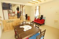 a dining room with a wooden table and a red chair at 貓咪民宿Mini館-中午即可入房 in Taitung City