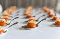 a row of silver spoons filled with orange food at Milano Verticale | UNA Esperienze in Milan