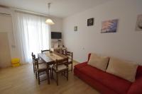 a living room with a table and a red couch at Apartment Lorela in Malinska