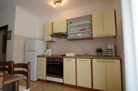 a kitchen with white cabinets and a white refrigerator at Apartment Lorela in Malinska