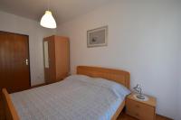 a bedroom with a bed and a dresser and a lamp at Apartment Lorela in Malinska