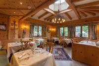 a restaurant with tables and chairs and a chandelier at Ferienhotel Sonnenhof in Zell am Ziller