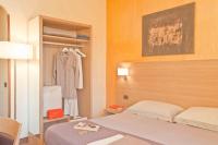 1 dormitorio con 1 cama y armario con albornoz en Hotel First, en Calenzano