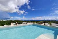 a swimming pool with a view of the ocean at MAYAN MONK Suites in Playa del Carmen