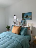 a bed with a blue comforter in a bedroom at vakantiehuis Cerise, Luxueus genieten in de Leiestreek in Deinze