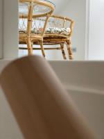 a wicker chair with a pillow sitting on a table at vakantiehuis Cerise, Luxueus genieten in de Leiestreek in Deinze