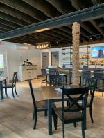 a dining room with tables and chairs and a kitchen at Smuggler's Cove Inn in Boothbay