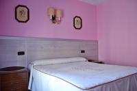 A bed or beds in a room at Hostal La Corte