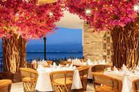 Un restaurante con mesas, sillas y flores. en Playa Los Arcos Hotel Beach Resort & Spa, en Puerto Vallarta