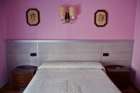 A bed or beds in a room at Hostal La Corte