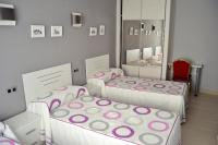 A bed or beds in a room at Hostal La Corte