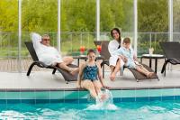Un grupo de personas sentadas alrededor de una piscina. en Hestia Hotel Strand, en Pärnu