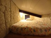 a bedroom with a bed in a stone wall at Résidence Royal Palmeraie in Aubagne