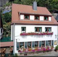 a white house with flower boxes on the side of it at Pension Fuhrmann&#39;s Elb- Café in Bad Schandau