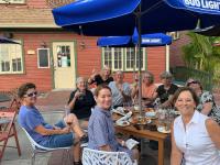 Un grupo de personas sentadas en una mesa bajo una sombrilla. en The Reserve Retreat, en Sarasota