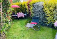 a garden with a table and a chair and an umbrella at Cottage Blagnac in Beauzelle