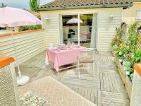 a patio with a pink table and chairs on it at Cottage Blagnac in Beauzelle