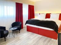Una habitación de hotel con una cama y dos sillas. en DORMERO Hotel Deggendorf, en Deggendorf