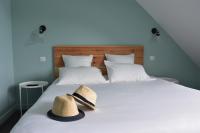 a hat is sitting on top of a bed at Hôtel Domaine du Lac Chambon in Murol