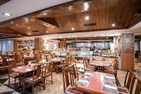 Un restaurante con mesas y sillas de madera y un bar. en Hotel Royal Chihpin, en Wenquan