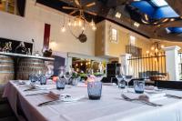 BassacにあるLogis Hôtel Restaurant L'Essilleのレストランにあるグラスとナプキンが置かれた長いテーブル