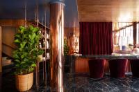 a kitchen with a bar with stools and a plant at Villa Marquis Member of Meliá Collection in Paris