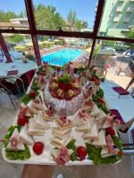 a plate of appetizers on a table near a pool at Hotel Prestigio in Cesenatico
