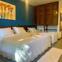 two large white beds in a room with blue walls at Hotel Pousada Marambaia in Arraial d'Ajuda