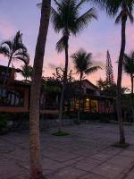 a group of palm trees in front of a building at Hotel Pousada Marambaia in Arraial d'Ajuda