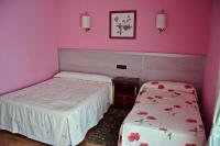 A bed or beds in a room at Hostal La Corte