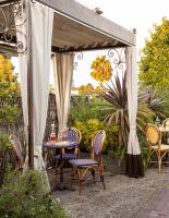 un patio con mesa y sillas bajo un dosel en Petit Ermitage, en Los Ángeles