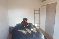 a teddy bear sitting on top of a bed at VILLA Adrien , maison de charme. in Casanova