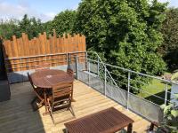 a wooden deck with a table and chairs and a fence at Gite PIPIOU ETAPLES 2 à 4 Personnes in Étaples