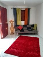 a living room with a couch and a red rug at Divima in Sainte-Anne