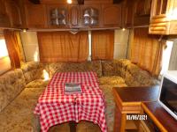a table with a book on it in an rv at Calme de la campagne in Le Torp-Mesnil