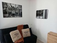 a living room with a couch with two pillows on it at Esprit industriel au pied du Futuroscope in Chasseneuil-du-Poitou