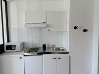 a white kitchen with a sink and a microwave at Esprit industriel au pied du Futuroscope in Chasseneuil-du-Poitou