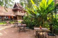 a patio with tables and chairs in front of a building at Yaang Come Village Hotel in Chiang Mai