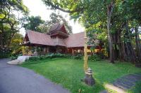 a house with a building with a roof at Yaang Come Village Hotel in Chiang Mai