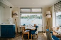 een eetkamer met een tafel en een groot raam bij Greenbank Hotel in Falmouth