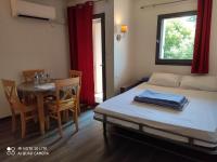 Habitación con cama, mesa, mesa y sillas. en Appartement Les Palmiers, en Niza