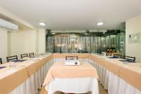 Una habitación con mesas largas con una máquina encima. en Hotel Dann Combeima, en Ibagué