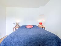 ein Schlafzimmer mit einem blauen Bett und einem roten Kissen in der Unterkunft Apartment La Cité du Lac-4 by Interhome in Saint-Jean-de-Luz