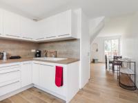 eine Küche mit weißen Schränken und einem roten Handtuch in der Unterkunft Apartment La Cité du Lac-4 by Interhome in Saint-Jean-de-Luz