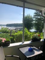 a table and chairs on a porch with a view of the water at Gast-&amp; Logierhaus Am Rheinsberger See in Rheinsberg