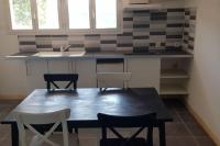 a kitchen with a table and chairs and a sink at Appartement dans le Massif du haut Jura in Dortan