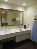 a bathroom with a sink and a large mirror at Anaheim Desert Inn & Suites in Anaheim