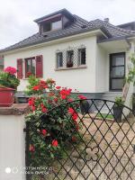 a white house with red flowers in front of it at Colmar , Séjour calme chez l&#39;habitant in Colmar
