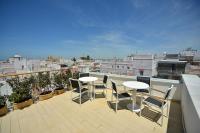 a balcony with tables and chairs on a roof at Plaza Mina Suites - Adults Recommended by Luxury Suites Cadiz in Cádiz